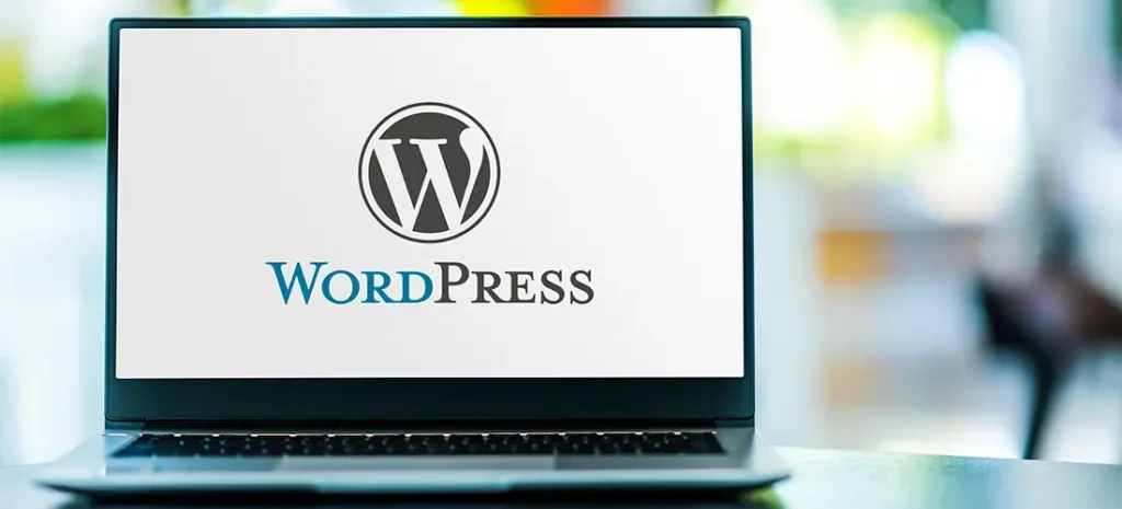se muestra una laptop mostrando el logotipo de wordpress